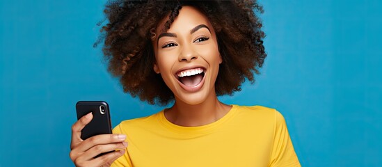 Blue shirted woman with afro hair takes selfies and video calls for freelance work on social media using a phone