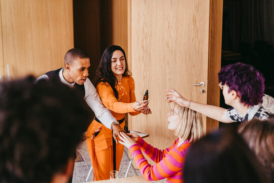 Businesswoman distributing essential oil samples to colleagues during event at convention center