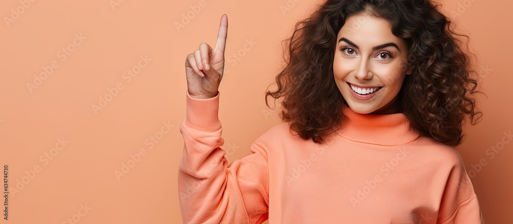 Poster Attractive woman happily pointing to the side and up with object in open area