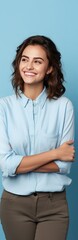 Naklejka premium Casually dressed woman on blue background smiling and presenting blank copy space