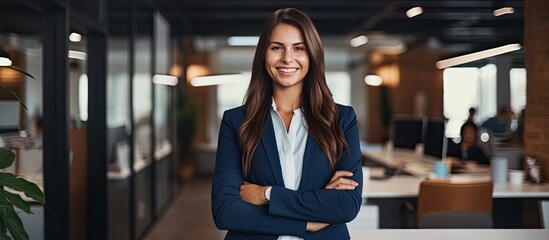 Smiling Caucasian woman manager in suit with folded arms surveys open area in contemporary office Professional lifestyle occupation advertisement and oppo