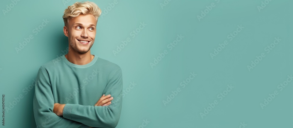 Poster happy and satisfied young man casually pointing to empty space with a cheerful smile