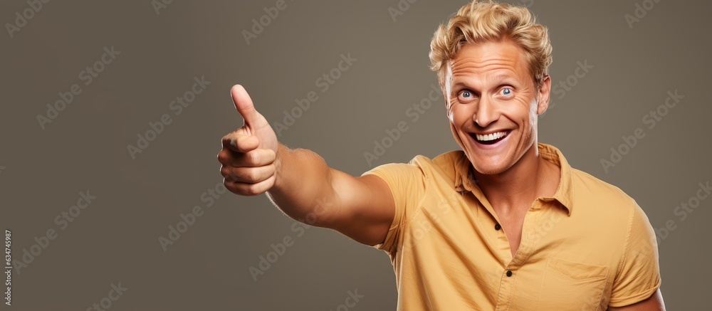 Poster happy adult male pointing and smiling indicating object in open area