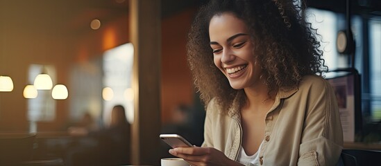 Caucasian woman in coffee shop happily looking at her cell phone while resting and enjoying good news