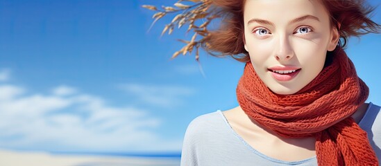 Portrait of a young Caucasian woman at the beach in August with a scarf and blue sky representing summer enjoyment and holiday concept - Powered by Adobe