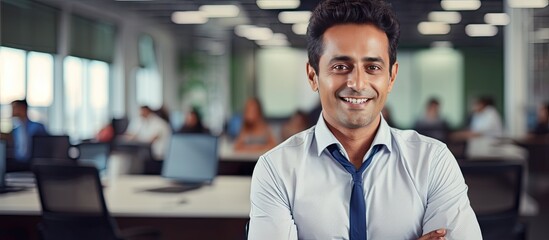 Fototapeta premium Confident Indian businessman smiling at camera in office copy space