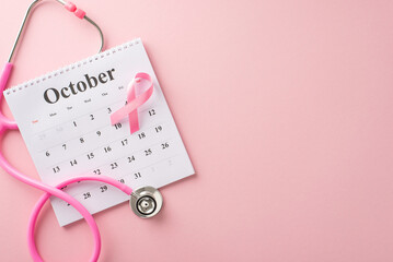 Promote breast cancer awareness during October. Top view image featuring a pink stethoscope, october calendar and pink ribbon on pastel pink isolated background, great for ads or text messages - Powered by Adobe