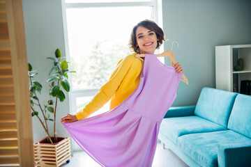 Photo of positive cheerful lady buying new dress online deliver order trying in apartment showroom