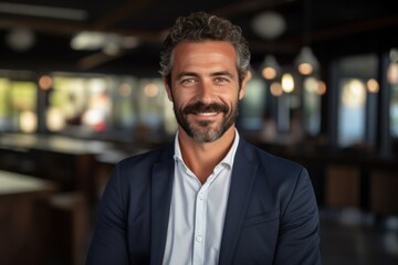 Obraz premium Happy young Latin businessman looking at a camera in the office, headshot portrait.