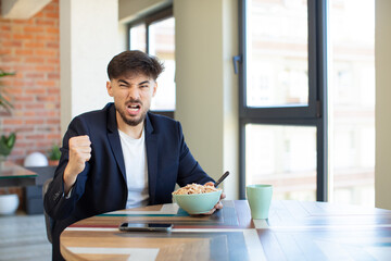 young handsome man looking angry, annoyed and frustrated. breakfast concept