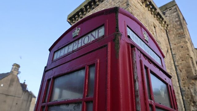 English Red Telephone Box on the Background of Old Architecture