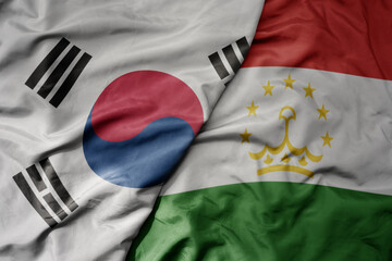 big waving realistic national colorful flag of south korea and national flag of tajikistan .