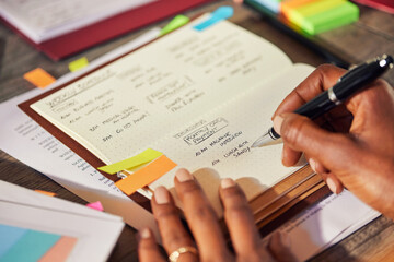 Close up of black businesswoman writing appointments on personal organizer
