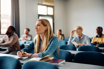 Mid adult woman paying attention during class in lecture hall.