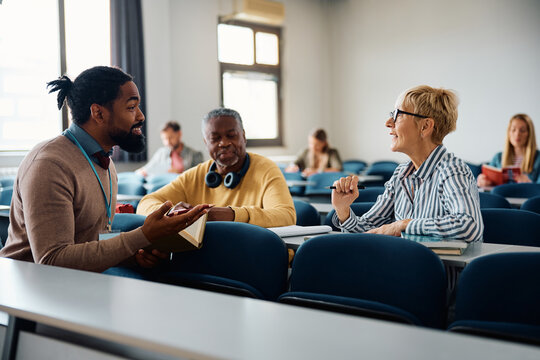 Black adult education teacher talking to his students during course in classroom.