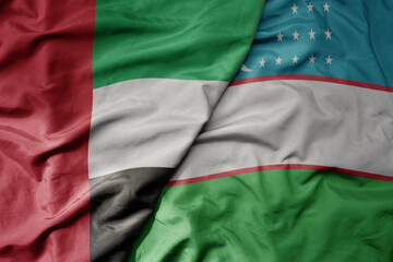 big waving realistic national colorful flag of united arab emirates and national flag of uzbekistan .
