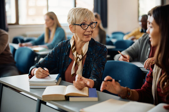 Female Adult Learners Communicating During Class In Lecture Hall.