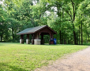The wood picnic shelter in the park on a sunny day.