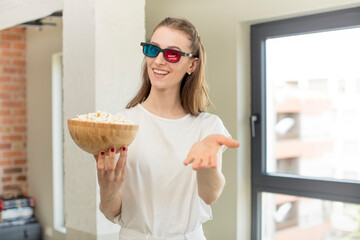 smiling happily and offering or showing a concept. popcorns and film concept