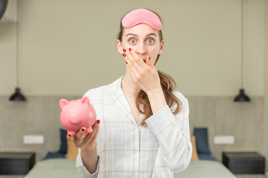 covering mouth with a hand and shocked or surprised expression. piggy bank concept