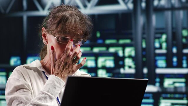 Older worker in server farm equipped to handle modern computing requirements, doing regular upgrades to infrastructure, increasing processing power and storage capacity to prevent problems