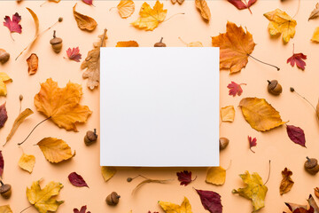 Autumn composition with paper blank and dried leaves on table. Flat lay, top view, copy space
