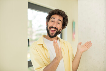 young crazy bearded man feeling happy and successful, smiling and clapping hands, saying...
