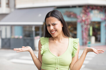 pretty hispanic woman looking puzzled, confused and stressed, wondering between different options,...
