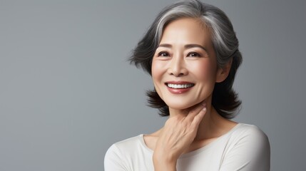 Fototapeta premium Close-up portrait of a beautiful and happy middle-aged Asian woman. Senior woman in her 50s looking