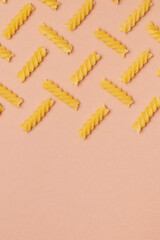 Pattern made of pasta on beige background. Close-up. Macro photo. Food concept. 