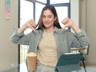 young pretty woman looking happy, confident and trustworthy, smiling and showing victory sign, with a positive attitude