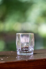 shot glass on a wooden table, with a green background 