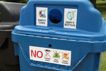 large blue recycle bin with circle opening and white sticker captions in black print that say empty...