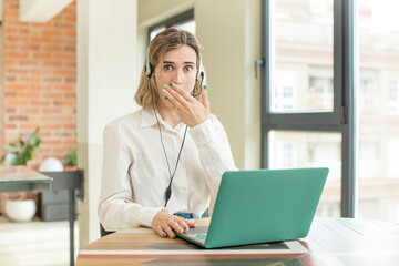 pretty woman covering mouth with a hand and shocked or surprised expression. telemarketer concept