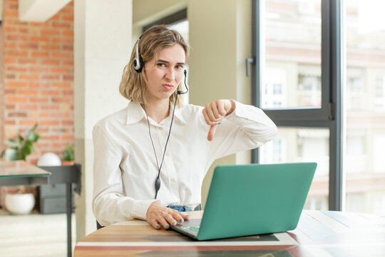 pretty woman feeling cross,showing thumbs down. telemarketer concept