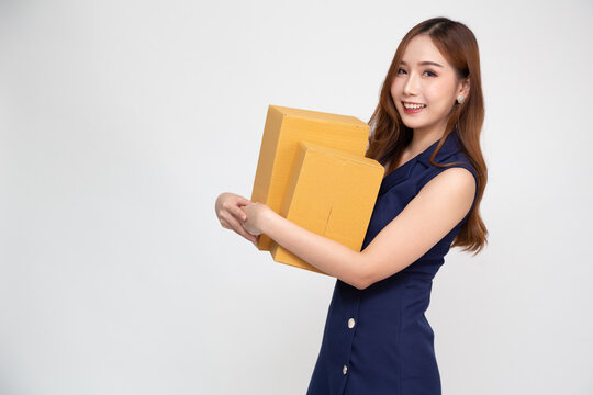 Happy Young Asian woman holding package parcel box isolated on white background, Delivery courier and shipping service concept