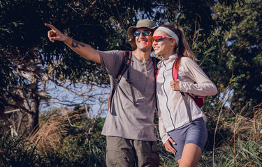Happy young couple traveling in the jungle forest near the ocean