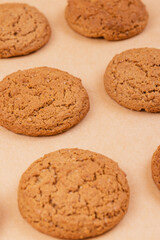 Sweet tasty oatmeal cookies on beige background.