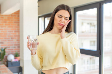 pretty young model feeling bored, frustrated and sleepy after a tiresome. water glass concept