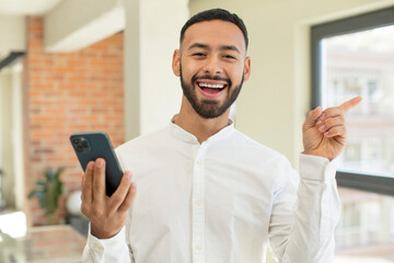 young  adult man feeling like a happy and excited genius after realizing an idea. smartphone concept