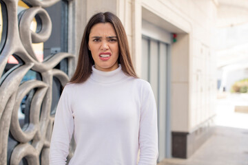 pretty young adult woman feeling terrified and shocked, with mouth wide open in surprise