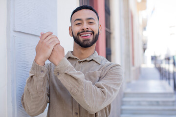 Obraz premium young handsome man feeling happy, surprised and proud, shouting and celebrating success with a big smile