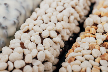 Sweet chocolate bars coated with corn cereals, peanuts pieces and  white icing. Macro shot.