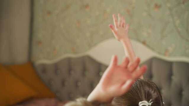 Boy and girl raise hands to answer question sitting at desk. Brother and sister study at home. Schoolchildren do homework with teacher in cozy room
