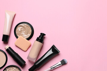 Obraz na płótnie Canvas Liquid foundation, beauty accessories and face powders on pink background, flat lay. Space for text