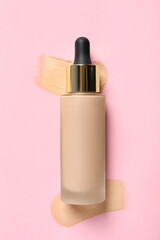 Liquid foundation and swatches on pink background, top view