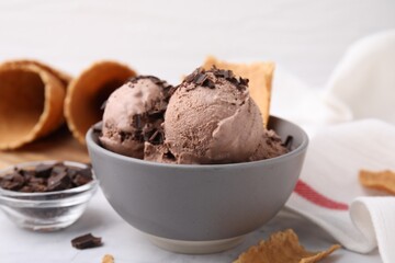 Bowl of tasty ice cream with chocolate chunks on table, closeup