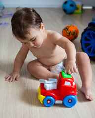 2 year old child playing with his stroller.