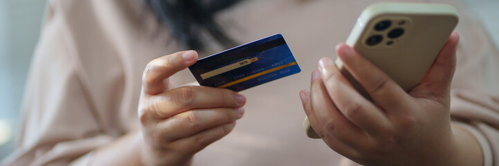 Close up hand using mobile phone and credit card for online payment, electronic wallet