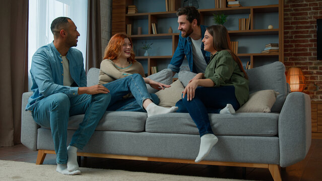 Group ethnic african american hispanic friends talking discussing future plans diverse multiracial middle-aged women men sit comfort on home couch chatting friendly conversation communicating together